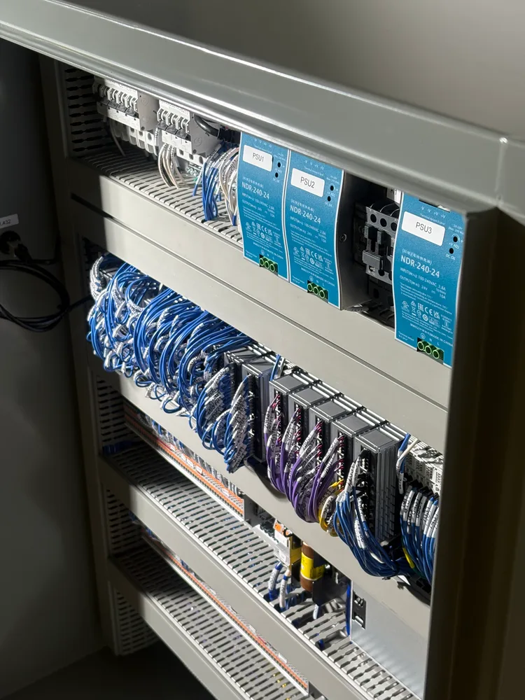 Angled interior view of Orbital Operations' DAQ panel, showing power supplies and wired I/O modules.